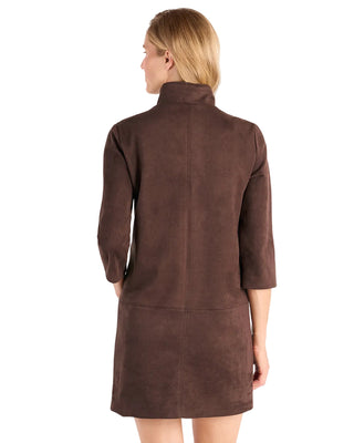 A woman shown from the back wearing a brown suede-like coat or dress with three-quarter sleeves and a high collar, photographed against a clean white studio background.