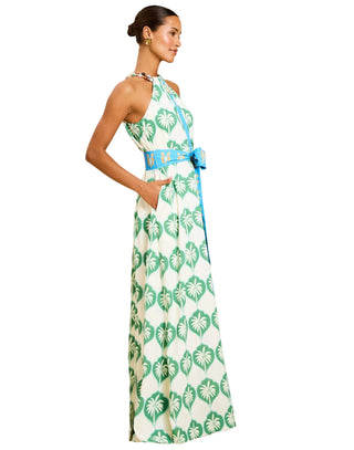 Woman wearing a floral dress with a blue belt on a beige background
