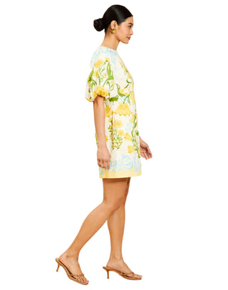 Woman wearing a floral dress with lemons on a beige background