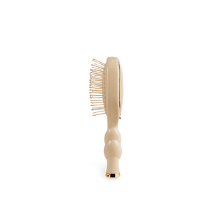 Beige hairbrush on a white background