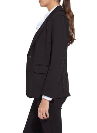 Person wearing a black suit with a blurred background