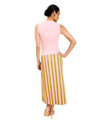 Woman wearing a pink sleeveless top and striped skirt on a beige background