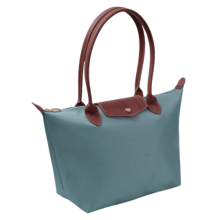 A teal blue tote bag with brown leather handles and a matching brown flap closure, shown on a plain white background.
