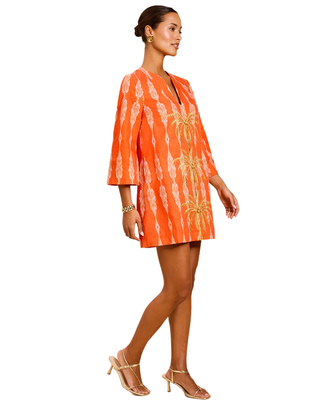 Woman wearing an orange tie-dye dress on a white background