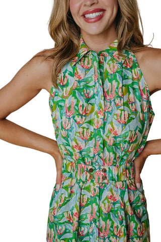 Woman wearing a green floral dress against a beige background