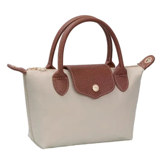 Beige handbag with brown handles and accents on a light background