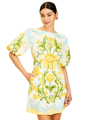 Woman wearing a floral dress with yellow flowers on a beige background