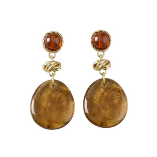 Pair of amber-colored earrings with gold accents on a light gray background