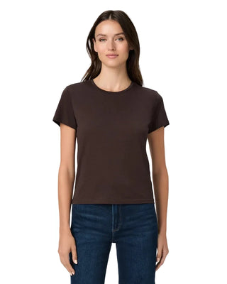 A woman modeling a dark brown short-sleeve crewneck t-shirt paired with dark blue jeans, shot against a solid light gray background.