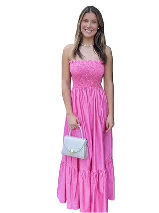 Woman in a pink dress standing in front of a white door.
