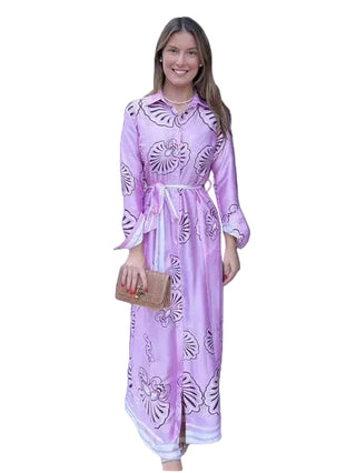 Woman in a pink dress standing outside a store