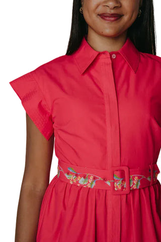 Red dress with floral belt worn by a person on a neutral background