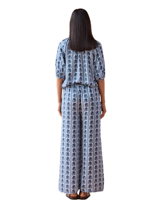 Woman wearing a blue and white patterned dress on a white background