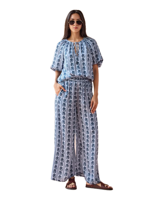 Woman wearing a blue and white patterned outfit on a white background