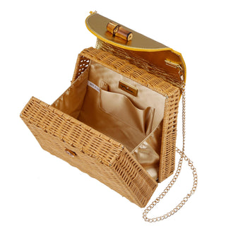 Capri woven straw handbag in natural gold featuring bamboo handle, sculpted satchel silhouette with 18-inch chain shoulder strap