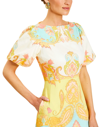 Woman wearing a colorful patterned dress with a white background