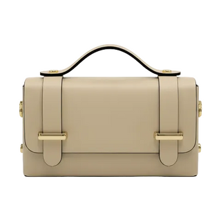 A structured beige leather handbag with a top handle, gold-tone hardware, and two front strap closures, shown against a plain white background.