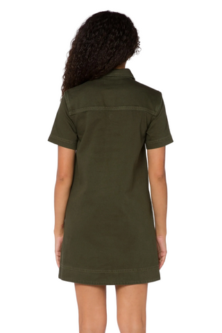 A model viewed from the back wearing an olive green short-sleeve shirt dress against a plain white background.